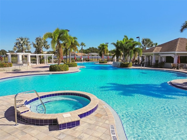 view of swimming pool with a patio area, a community hot tub, and a pergola