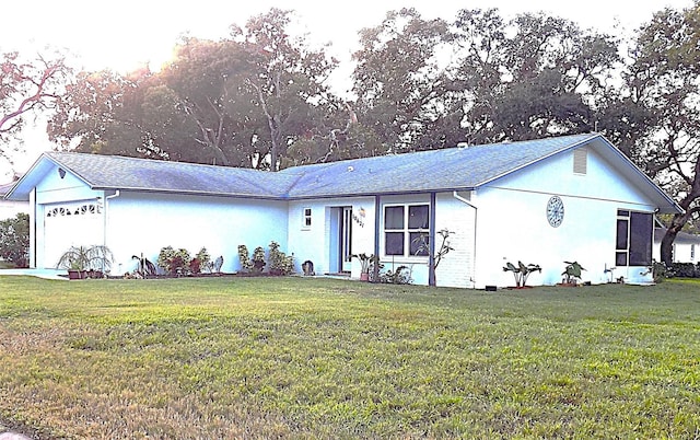 ranch-style home featuring a garage and a front lawn