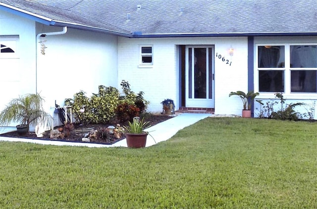 doorway to property featuring a lawn