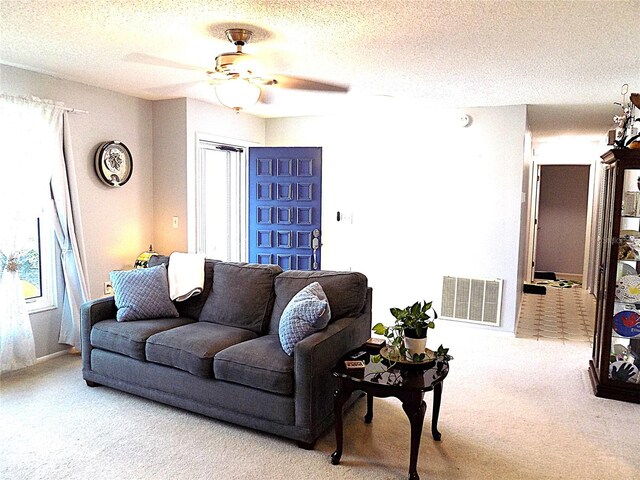 living room with a wealth of natural light, carpet, and a textured ceiling