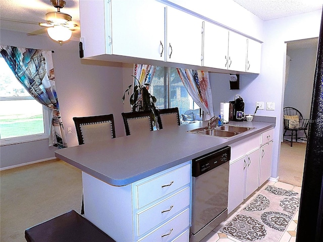 kitchen with dishwasher, light carpet, white cabinetry, and ceiling fan