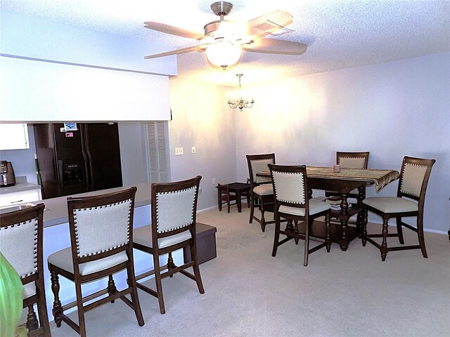 carpeted dining space featuring ceiling fan with notable chandelier and a textured ceiling