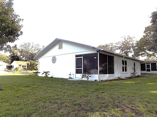 view of side of home featuring a yard and a sunroom