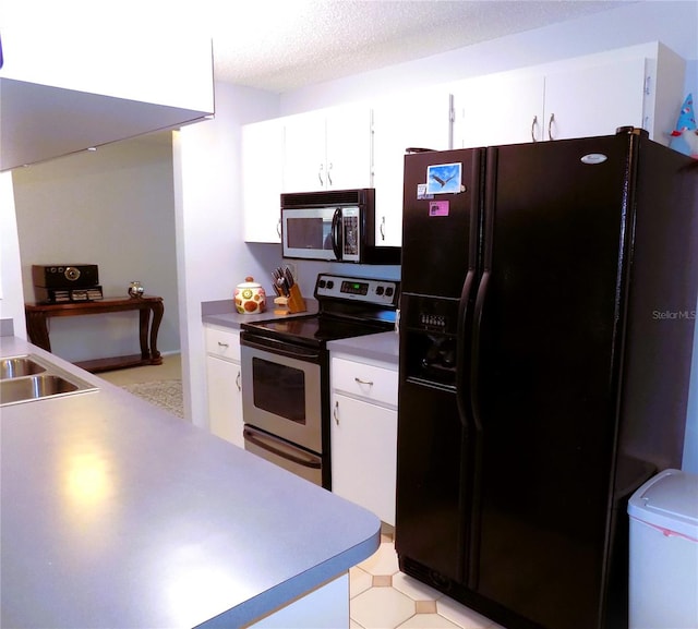 kitchen featuring appliances with stainless steel finishes, a textured ceiling, and white cabinetry