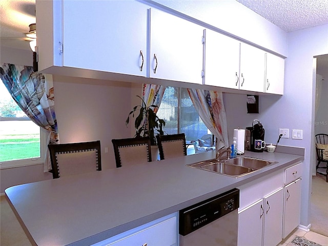 kitchen featuring white cabinets, a textured ceiling, ceiling fan, sink, and dishwasher