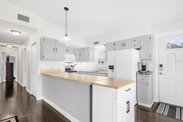 kitchen featuring white appliances, decorative backsplash, butcher block countertops, decorative light fixtures, and dark hardwood / wood-style flooring