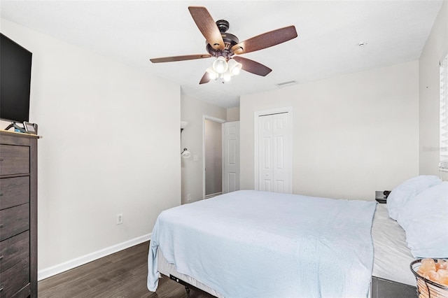 bedroom with ceiling fan, a closet, and dark hardwood / wood-style floors