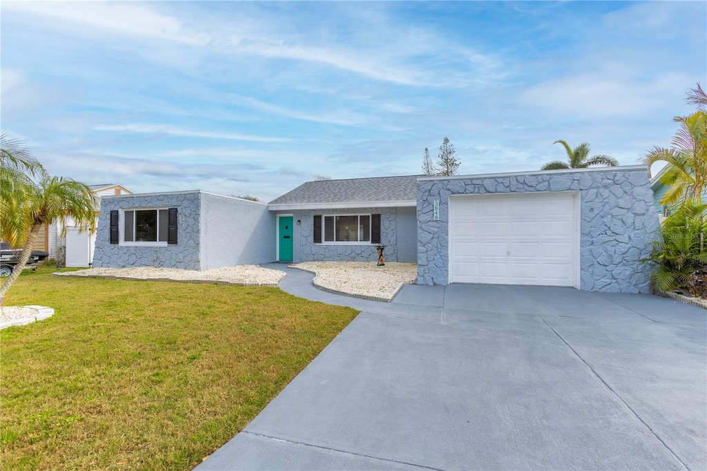 view of front of house with an attached garage, stucco siding, driveway, and a front yard