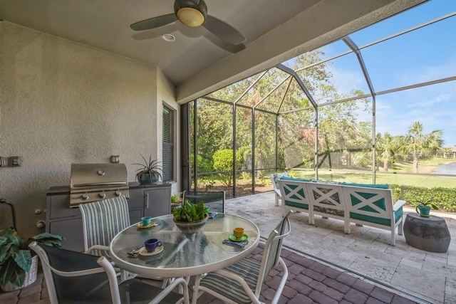 view of patio / terrace featuring glass enclosure, area for grilling, and ceiling fan