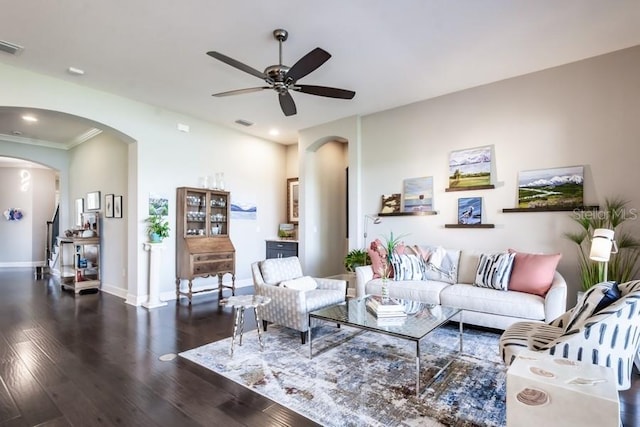 living room featuring dark hardwood / wood-style floors, ceiling fan, and ornamental molding