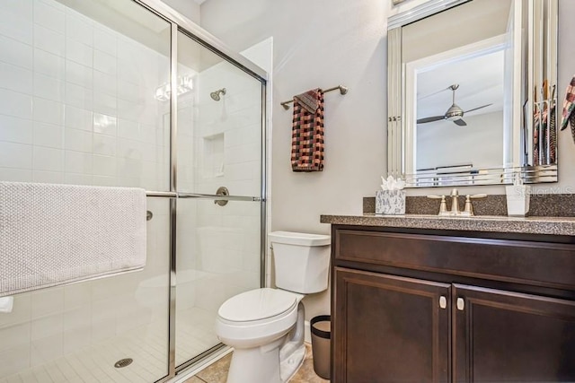 bathroom featuring vanity, toilet, walk in shower, and ceiling fan