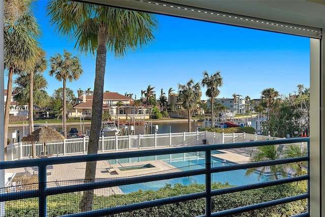 view of swimming pool featuring an in ground hot tub and a water view