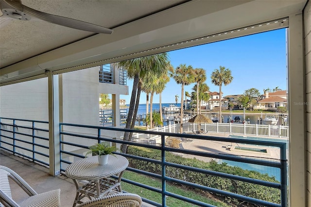 balcony with a water view and ceiling fan