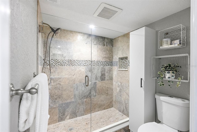 bathroom with toilet and a shower with shower door