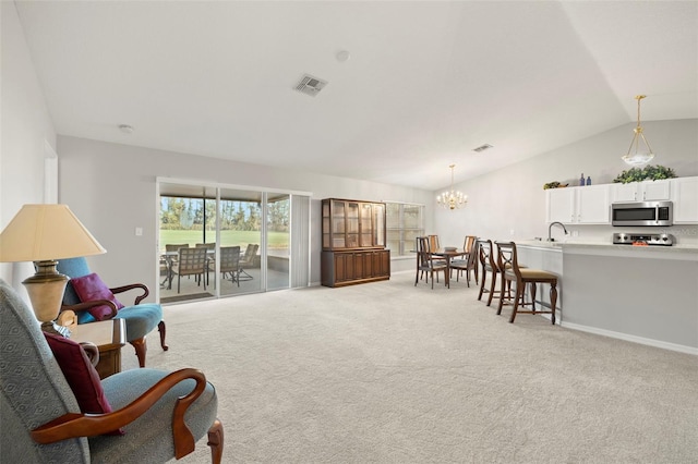 living area featuring light carpet, vaulted ceiling, and a notable chandelier