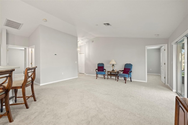 sitting room featuring lofted ceiling and light carpet