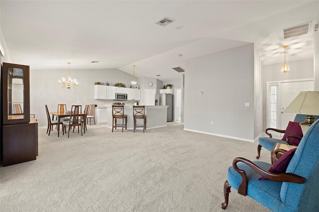 sitting room featuring light carpet, vaulted ceiling, and an inviting chandelier