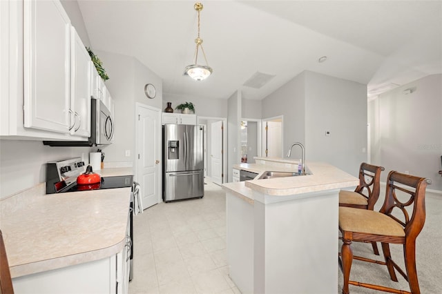 kitchen featuring stainless steel appliances, a kitchen island with sink, sink, decorative light fixtures, and white cabinetry