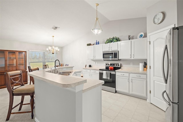 kitchen featuring decorative light fixtures, sink, stainless steel appliances, and lofted ceiling