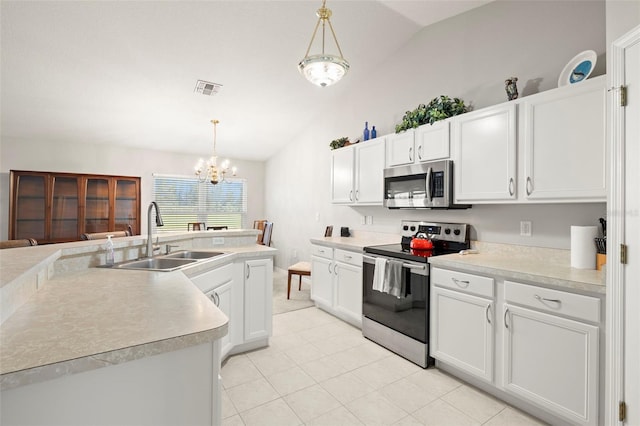 kitchen featuring white cabinets, sink, vaulted ceiling, decorative light fixtures, and stainless steel appliances