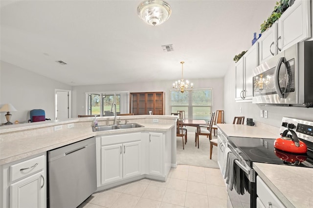 kitchen featuring white cabinets, sink, appliances with stainless steel finishes, and an inviting chandelier