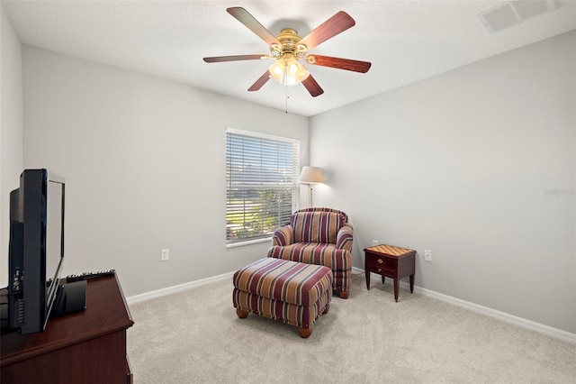 living area with ceiling fan and light carpet