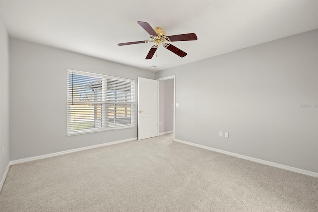 spare room featuring light carpet and ceiling fan