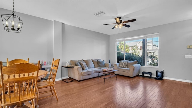 living room featuring wood-type flooring and ceiling fan with notable chandelier