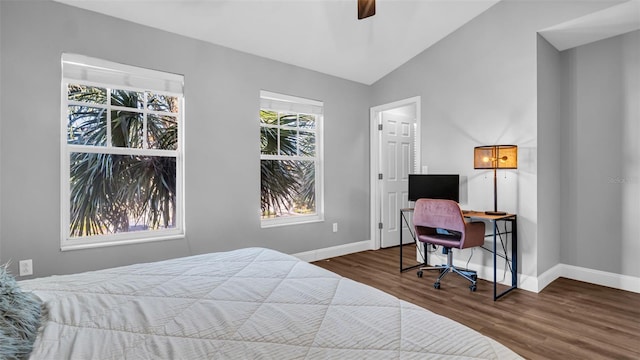 bedroom with dark hardwood / wood-style flooring, vaulted ceiling, and ceiling fan