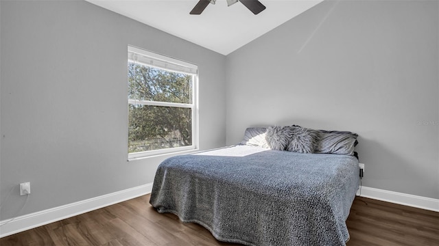 bedroom featuring multiple windows, ceiling fan, dark hardwood / wood-style floors, and lofted ceiling