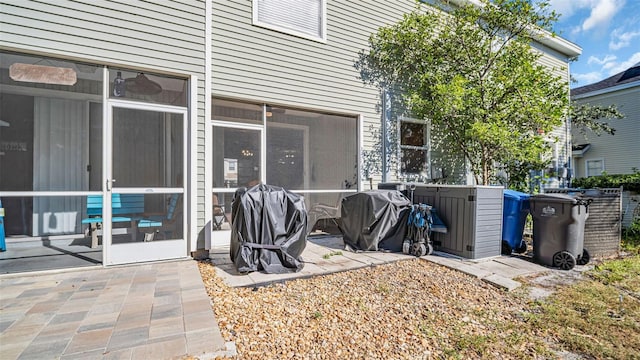 view of patio with grilling area and a sunroom