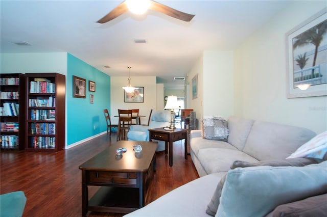 living room with dark hardwood / wood-style flooring and ceiling fan