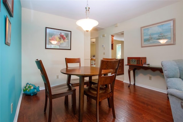 dining area featuring dark wood-type flooring