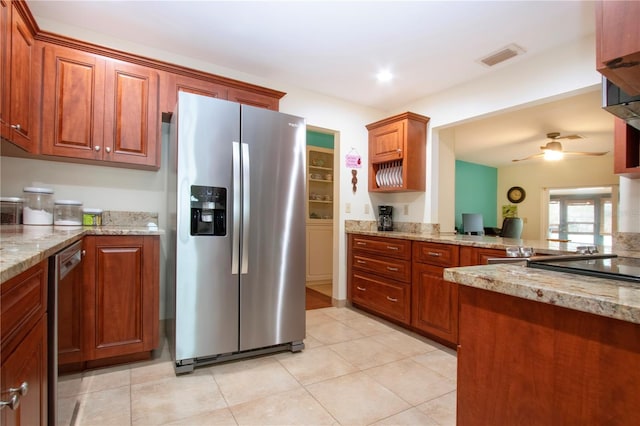 kitchen with ceiling fan, light tile patterned flooring, light stone counters, and stainless steel appliances