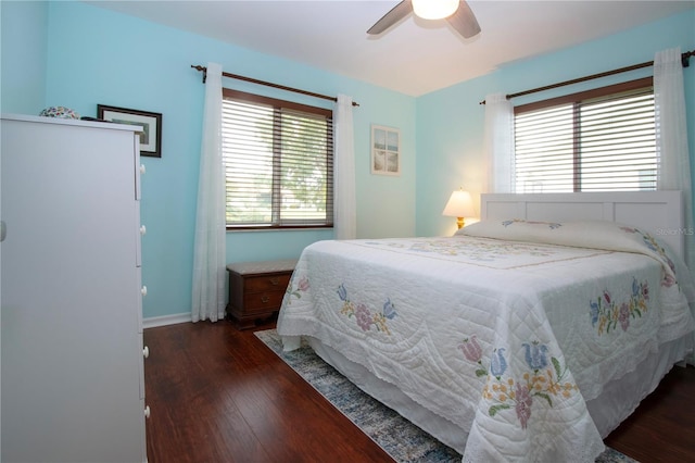 bedroom with multiple windows, ceiling fan, and dark wood-type flooring