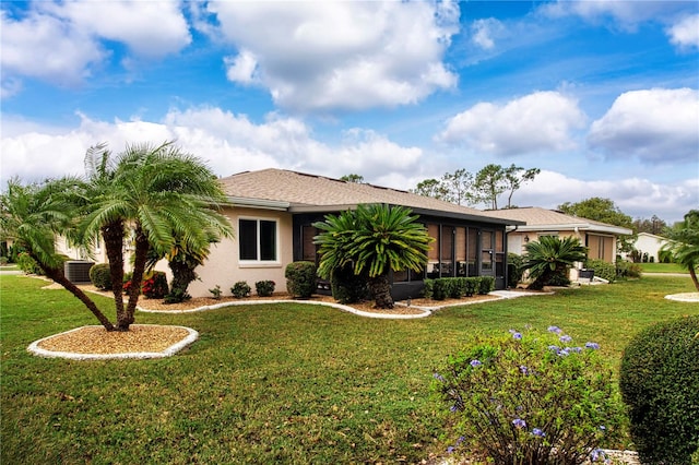 view of front of home with central air condition unit, a sunroom, and a front yard