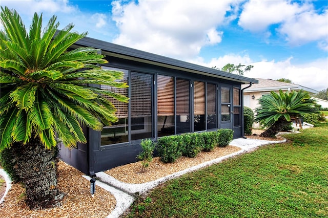 view of side of property featuring a yard and a sunroom