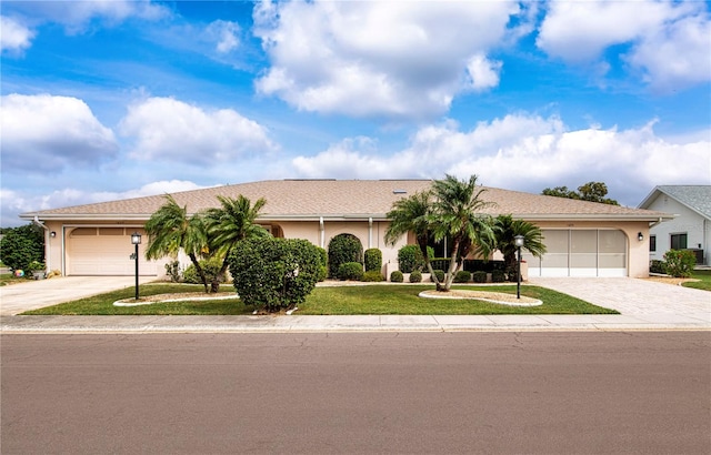 ranch-style home featuring a garage and a front lawn