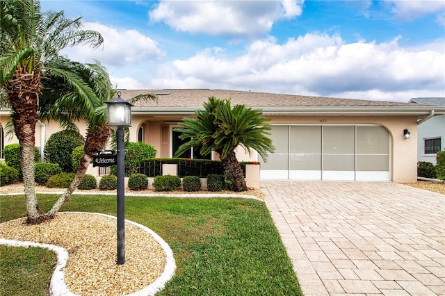 view of front of property with a front yard and a garage