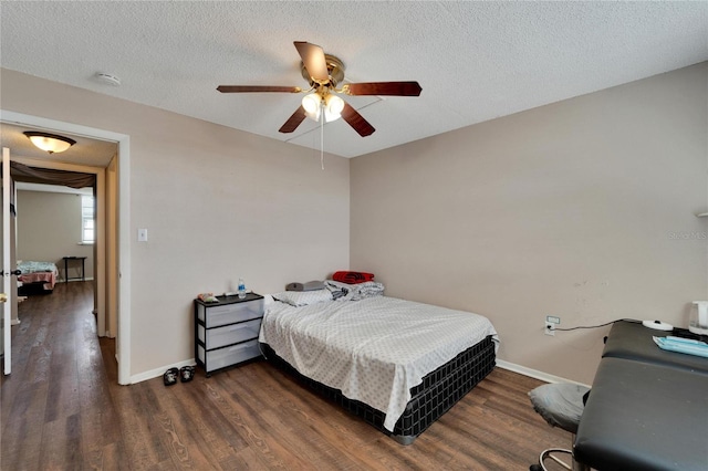 bedroom with ceiling fan, dark hardwood / wood-style flooring, and a textured ceiling