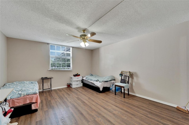 bedroom featuring ceiling fan, dark hardwood / wood-style flooring, and a textured ceiling