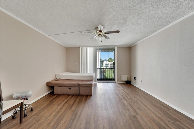 spare room with wood-type flooring, a textured ceiling, ceiling fan, and ornamental molding