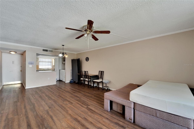 sitting room featuring crown molding, ceiling fan with notable chandelier, dark wood-type flooring, and a textured ceiling