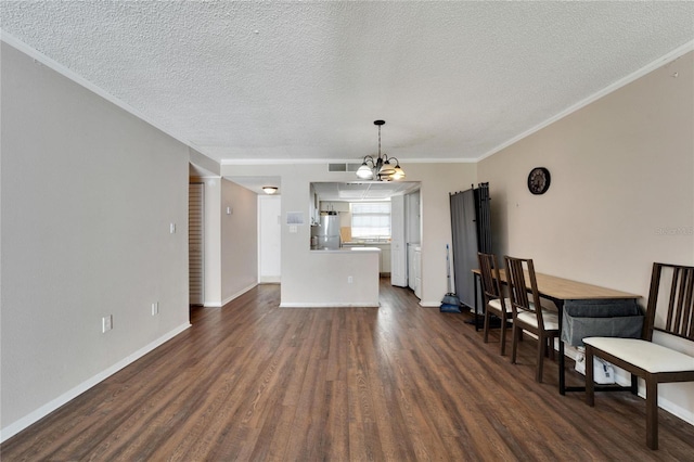 living room featuring a notable chandelier, dark hardwood / wood-style floors, ornamental molding, and a textured ceiling