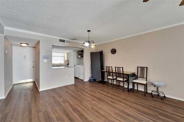 interior space featuring a textured ceiling, washing machine and dryer, dark hardwood / wood-style floors, and crown molding