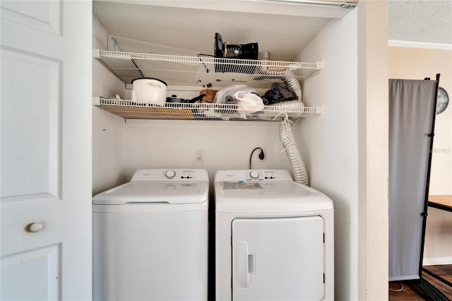 laundry area with separate washer and dryer and a textured ceiling