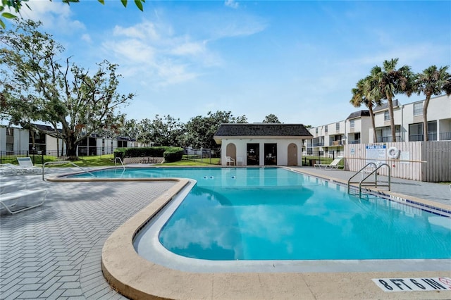 view of pool featuring an outbuilding and a patio