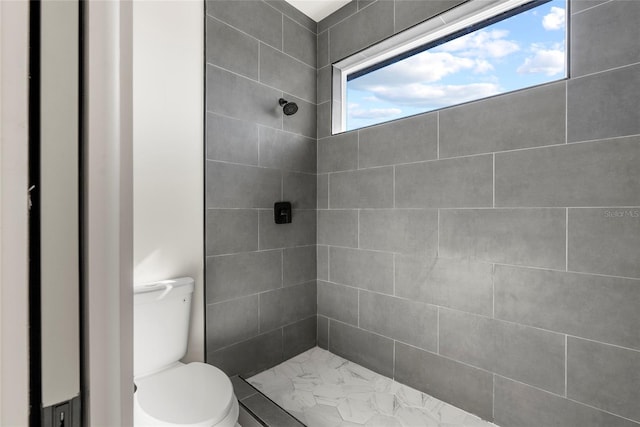 bathroom with toilet and a tile shower