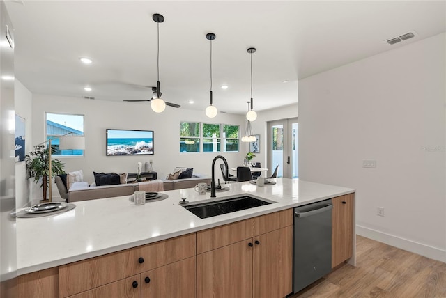 kitchen featuring ceiling fan, sink, stainless steel dishwasher, pendant lighting, and light hardwood / wood-style floors