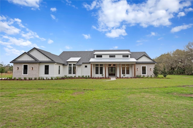 view of front of home featuring brick siding, a porch, board and batten siding, and a front yard